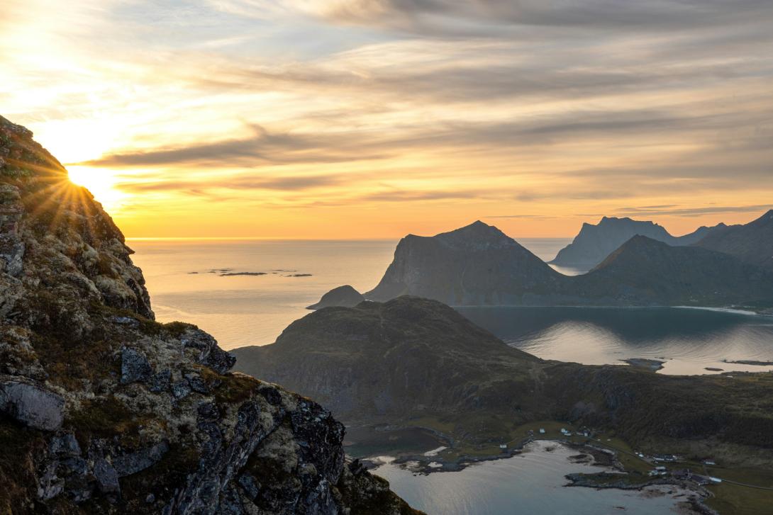 Solnedgang med fjell og hav